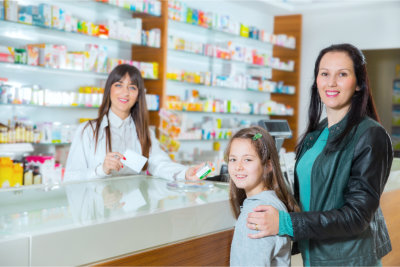 Pharmacist giving vitamins to a child in drugstore